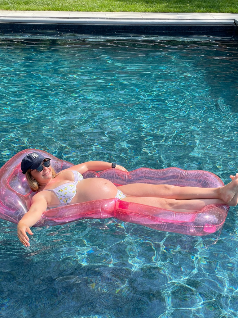Amanda Seibert blogger floating in her heated pool while pregnant.